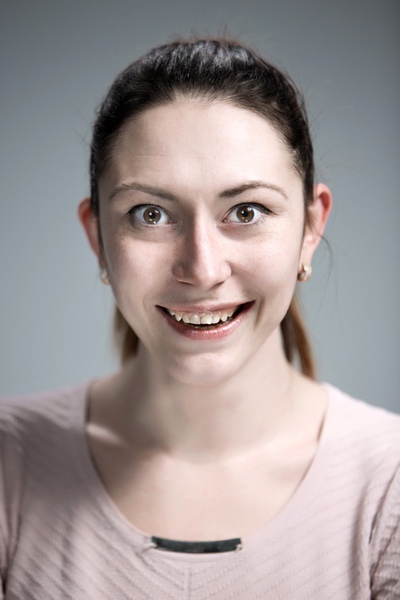 Woman smiling warmly against a neutral background